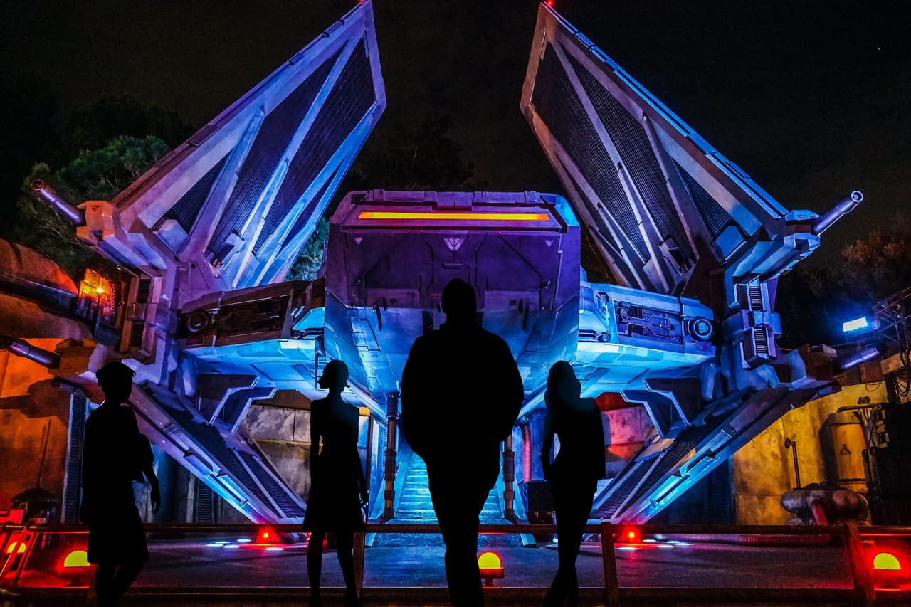 Photo of people in front of vintage a printed image of a space craft